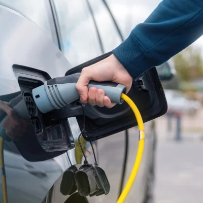 hombre-enchufando-el-cargador-en-un-coche-electrico-en-la-estacion-de-carga